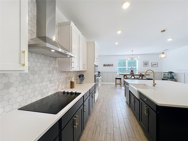 2044 Keystone Pass Blvd, Minneola, FL 34715 - kitchen featuring wall chimney exhaust hood, stainless steel appliances, light wood-type flooring, dark cabinets, and light countertops