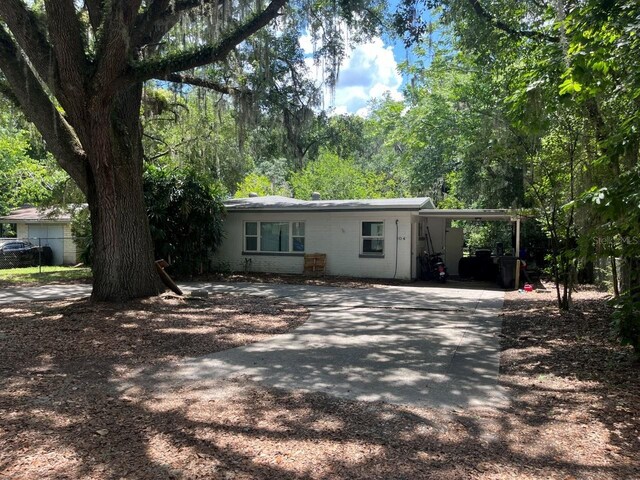 104 SW 26th St, Gainesville, FL 32607 - view of front of home with driveway, a carport, and concrete block siding