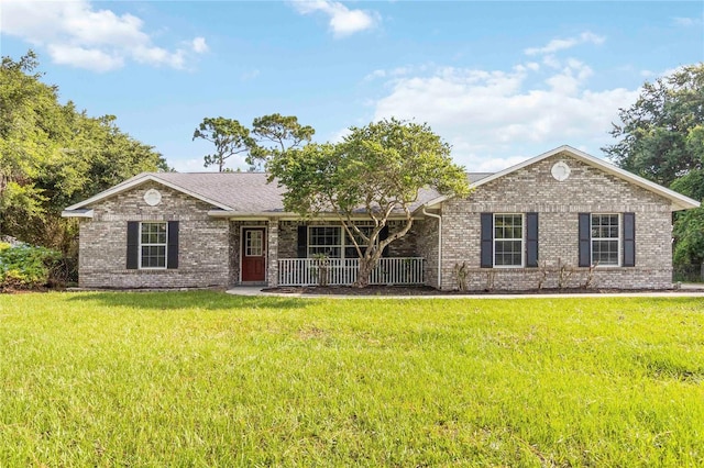 1330 Englewood Dr, Saint Cloud, FL 34772 - single story home featuring brick siding, a porch, a front lawn, and roof with shingles