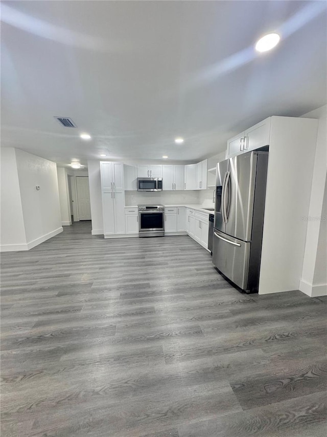 4934 Avery Rd, New Port Richey, FL 34652 - kitchen featuring stainless steel appliances, wood finished floors, recessed lighting, white cabinetry, and light countertops