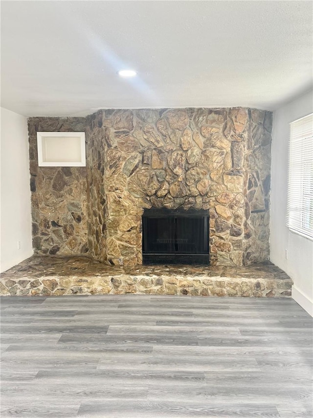 4934 Avery Rd, New Port Richey, FL 34652 - unfurnished living room with wood finished floors and a stone fireplace