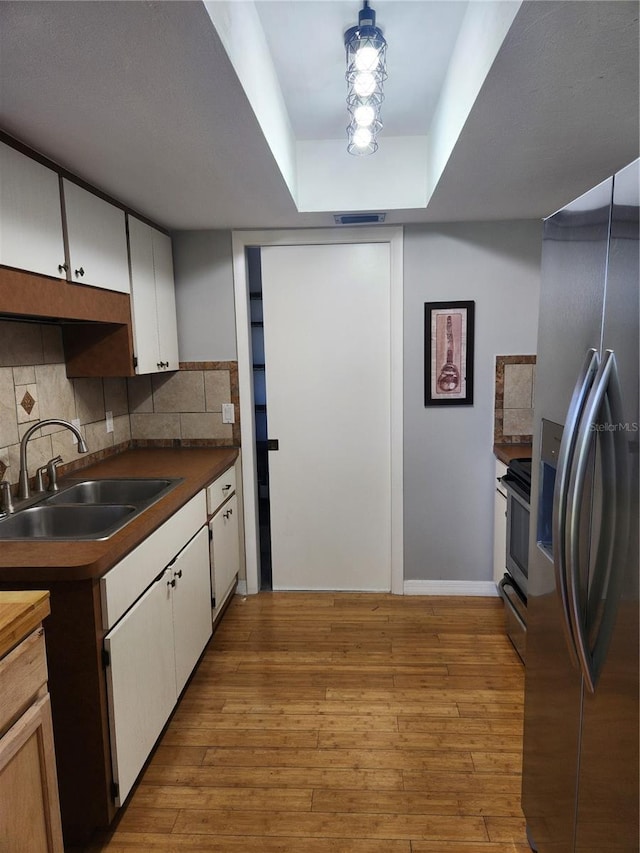 22481 Westchester Blvd Unit A19, Punta Gorda, FL 33980 - kitchen with appliances with stainless steel finishes, wood-type flooring, backsplash, and white cabinetry