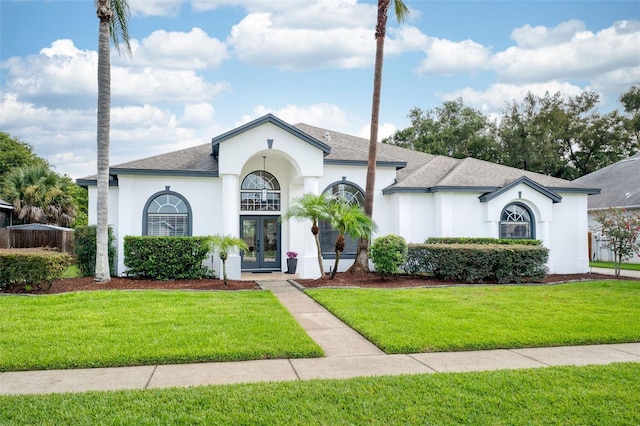 9844 Montclair Cir, Apopka, FL 32703 - french country style house with french doors, a front yard, stucco siding, and a shingled roof