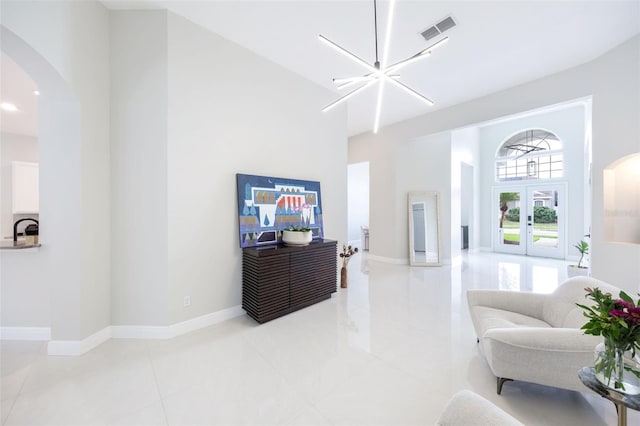 9844 Montclair Cir, Apopka, FL 32703 - living room featuring arched walkways, french doors, a towering ceiling, and light tile patterned floors