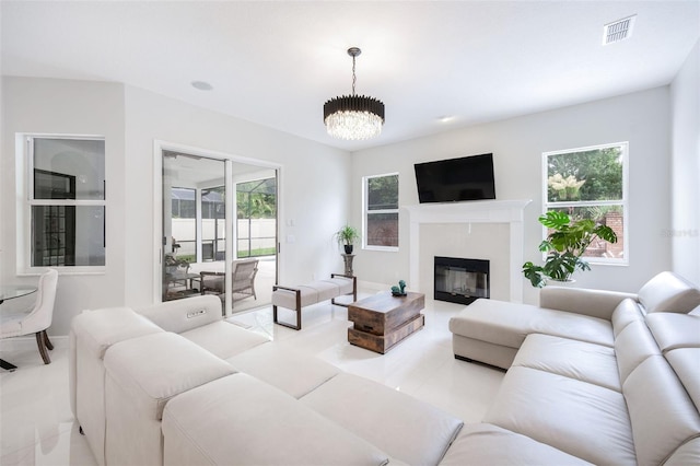 9844 Montclair Cir, Apopka, FL 32703 - living room featuring healthy amount of natural light, a chandelier, and a glass covered fireplace