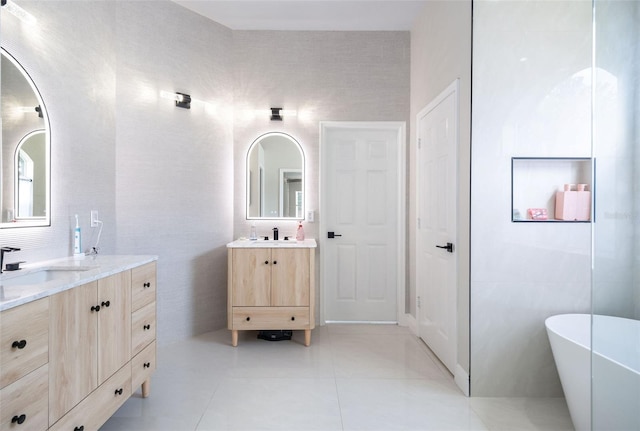 9844 Montclair Cir, Apopka, FL 32703 - bathroom featuring two vanities, a freestanding tub, and tile patterned flooring