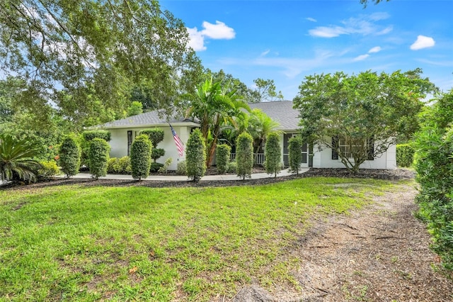 11442 Beggs Ct, Clermont, FL 34711 - view of property hidden behind natural elements with a front yard, stucco siding, and roof with shingles