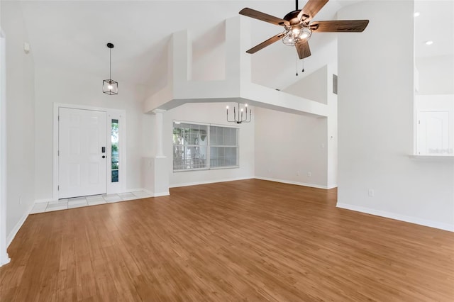 11442 Beggs Ct, Clermont, FL 34711 - entryway with high vaulted ceiling, wood finished floors, a ceiling fan, and a chandelier