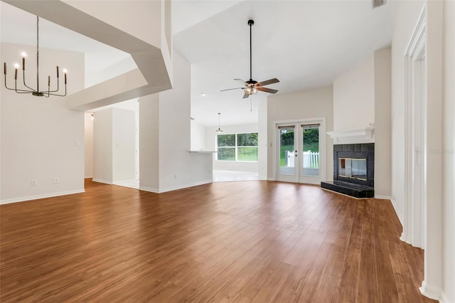 11442 Beggs Ct, Clermont, FL 34711 - unfurnished living room with ceiling fan, a chandelier, wood finished floors, and a tile fireplace