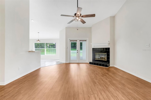 11442 Beggs Ct, Clermont, FL 34711 - unfurnished living room with light wood finished floors, a ceiling fan, and a tile fireplace