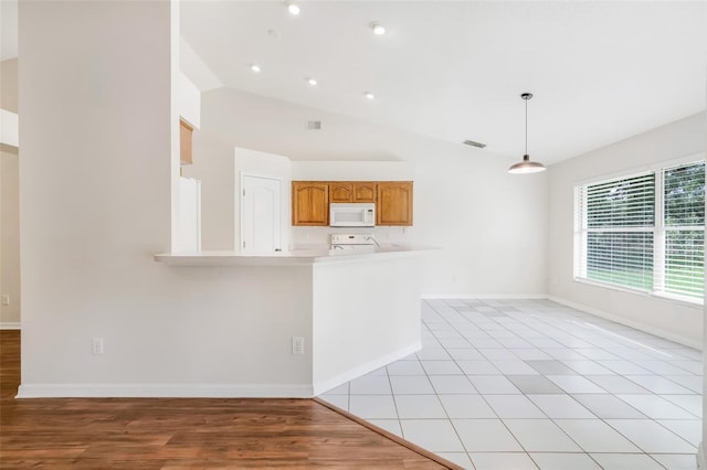 11442 Beggs Ct, Clermont, FL 34711 - kitchen with white microwave, range, light countertops, pendant lighting, and a peninsula