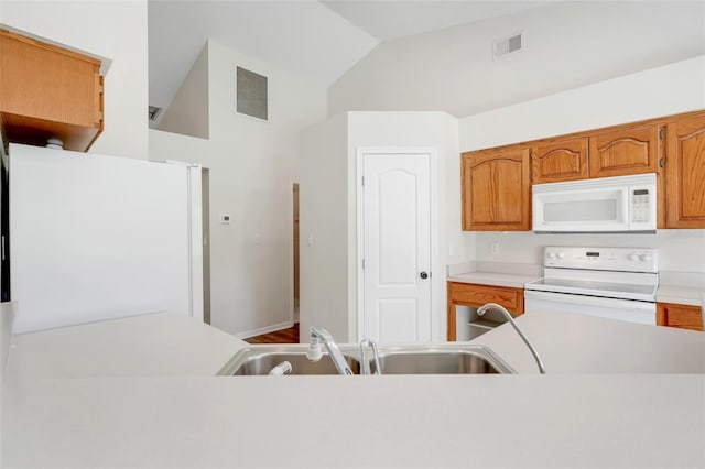 11442 Beggs Ct, Clermont, FL 34711 - kitchen featuring white appliances, light countertops, lofted ceiling, and brown cabinetry