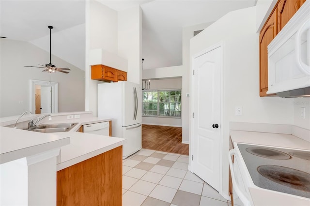 11442 Beggs Ct, Clermont, FL 34711 - kitchen with white appliances, light countertops, brown cabinetry, high vaulted ceiling, and a ceiling fan