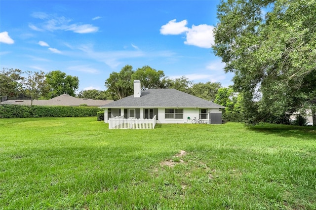 11442 Beggs Ct, Clermont, FL 34711 - back of property with a chimney, a yard, and a shingled roof