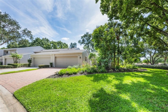 7755 High Pine Rd, Orlando, FL 32819 - view of front of property with decorative driveway, a front lawn, stucco siding, and an attached garage