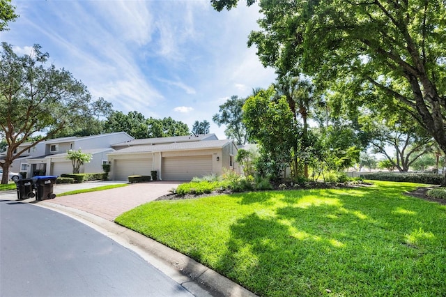 7755 High Pine Rd, Orlando, FL 32819 - view of front of property with driveway, a front yard, a garage, and stucco siding