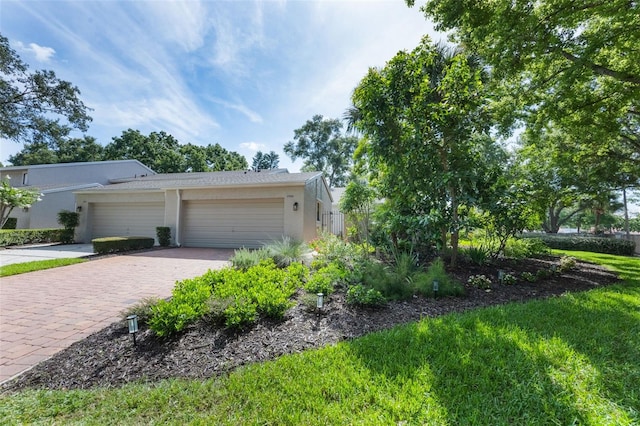 7755 High Pine Rd, Orlando, FL 32819 - view of home's exterior with stucco siding, an attached garage, and driveway