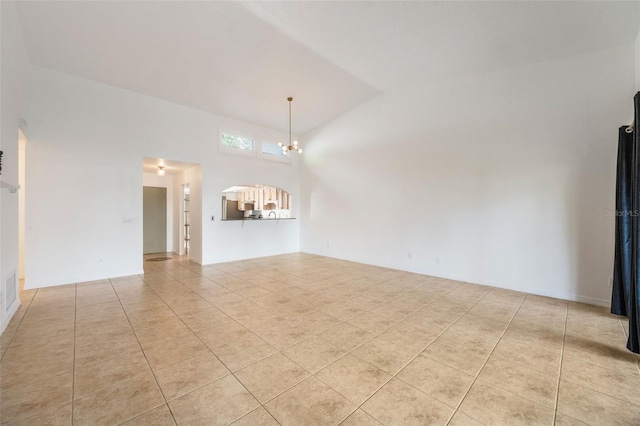 7755 High Pine Rd, Orlando, FL 32819 - unfurnished living room with tile patterned floors, a chandelier, vaulted ceiling, and arched walkways