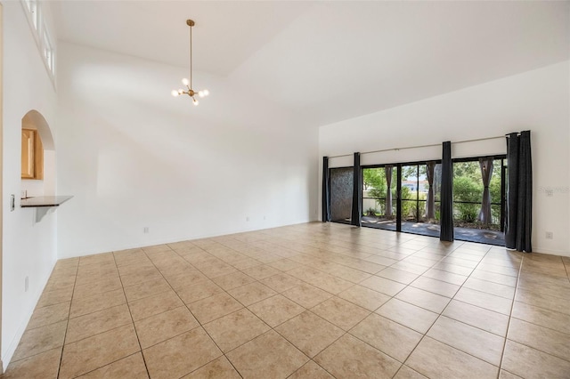 7755 High Pine Rd, Orlando, FL 32819 - spare room with light tile patterned floors, a chandelier, and high vaulted ceiling