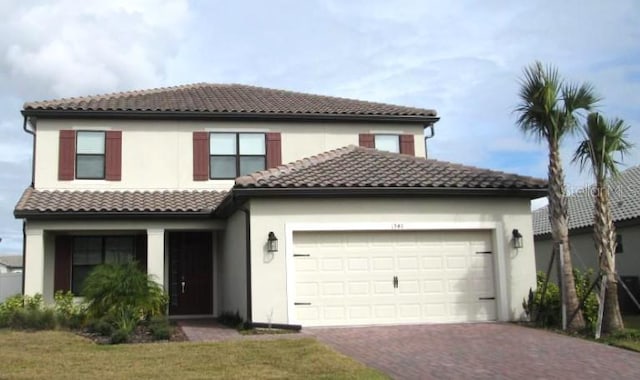 1940 Goblet Cove St, Kissimmee, FL 34746 - mediterranean / spanish house with a garage, a tiled roof, decorative driveway, and stucco siding