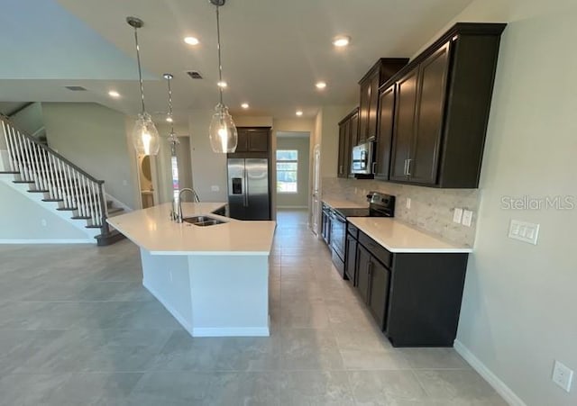 1940 Goblet Cove St, Kissimmee, FL 34746 - kitchen with stainless steel appliances, a kitchen island with sink, recessed lighting, dark brown cabinetry, and light countertops