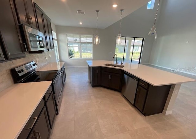 1940 Goblet Cove St, Kissimmee, FL 34746 - kitchen featuring stainless steel appliances, healthy amount of natural light, dark brown cabinetry, backsplash, and recessed lighting