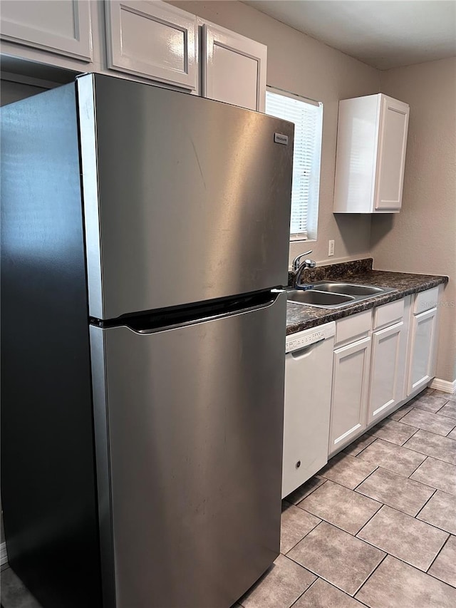 3304 Dew Berry Ave, Apopka, FL 32712 - kitchen featuring freestanding refrigerator, white dishwasher, dark countertops, and white cabinetry