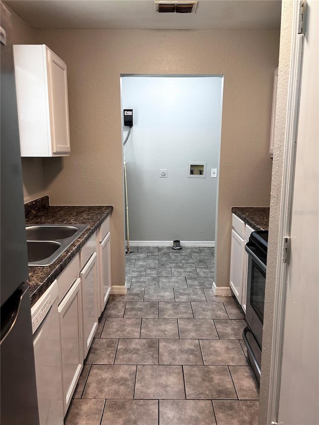 3304 Dew Berry Ave, Apopka, FL 32712 - kitchen with stainless steel appliances, dark countertops, white cabinetry, and tile patterned flooring