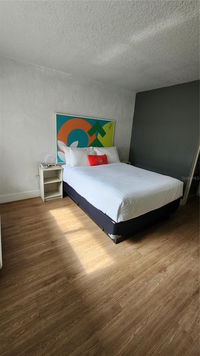 5367 W Irlo Bronson Memorial Hwy Unit 2-206, Kissimmee, FL 34746 - bedroom with wood finished floors and a textured ceiling