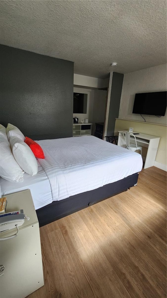 5367 W Irlo Bronson Memorial Hwy Unit 2-206, Kissimmee, FL 34746 - bedroom with wood finished floors, a closet, and a textured ceiling