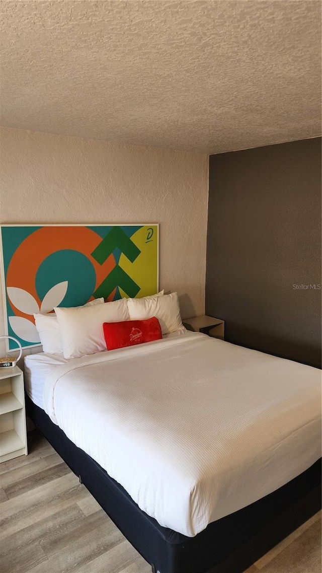 5367 W Irlo Bronson Memorial Hwy Unit 3-216, Kissimmee, FL 34746 - bedroom with wood finished floors, a textured wall, and a textured ceiling