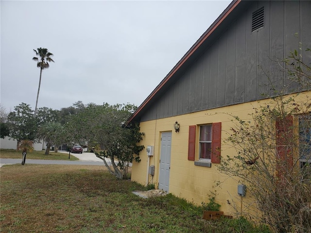 view of side of home with a yard