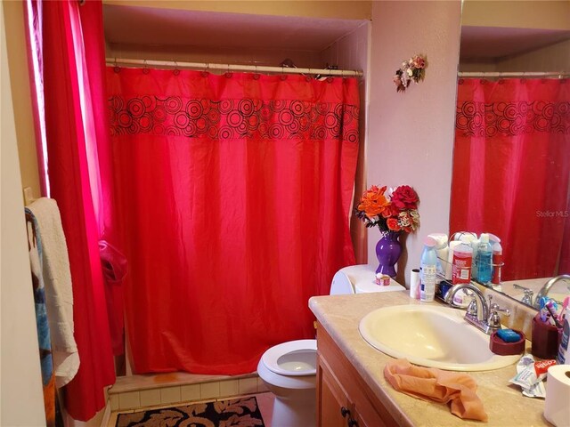 bathroom with tile flooring, large vanity, and toilet