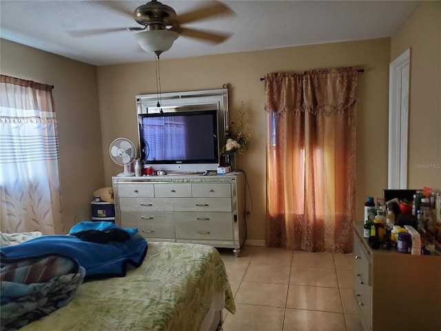 tiled bedroom featuring ceiling fan and multiple windows