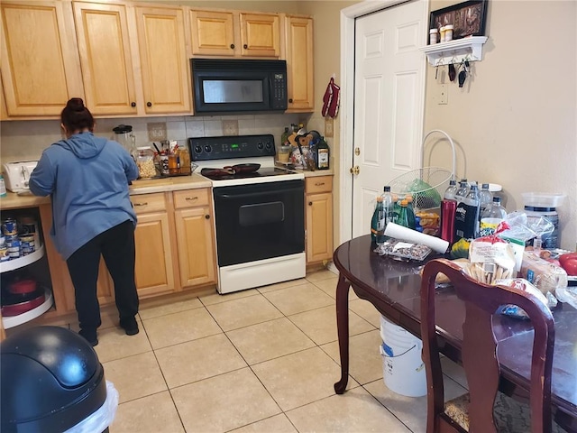 kitchen featuring light tile floors, light brown cabinets, and white electric range oven