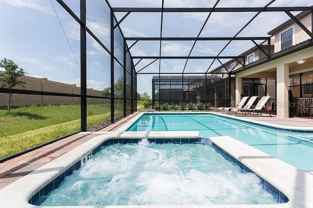 view of pool featuring a lanai, an in ground hot tub, and a patio area