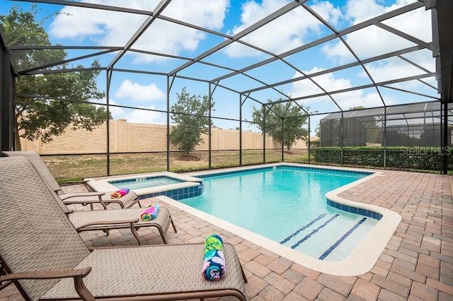 view of swimming pool featuring a lanai, a patio, and an in ground hot tub