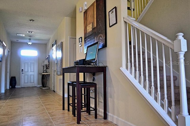 entrance foyer featuring a textured ceiling and tile patterned flooring