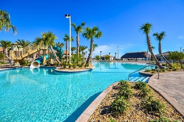 view of swimming pool featuring a water slide and a patio