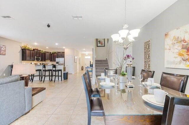 dining room with light tile patterned flooring and an inviting chandelier