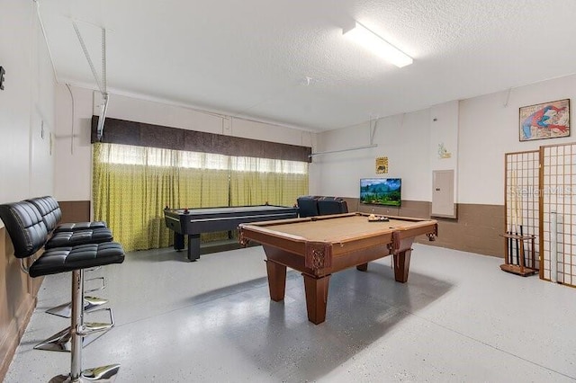 recreation room with pool table, electric panel, and a textured ceiling