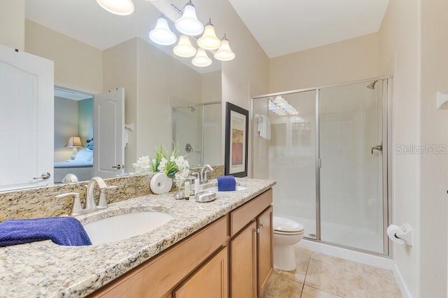 bathroom with walk in shower, vanity, toilet, and tile patterned floors