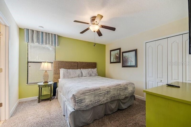 bedroom featuring ceiling fan, a textured ceiling, carpet flooring, and a closet