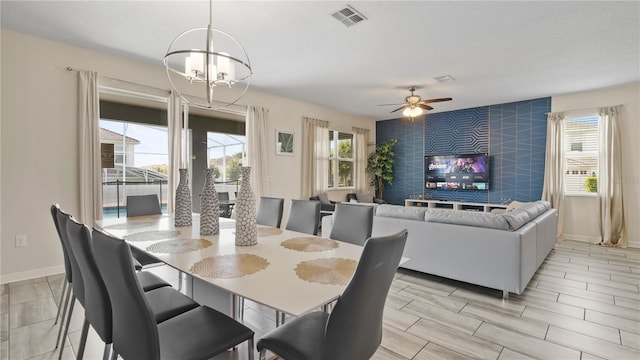 dining room featuring plenty of natural light and ceiling fan with notable chandelier