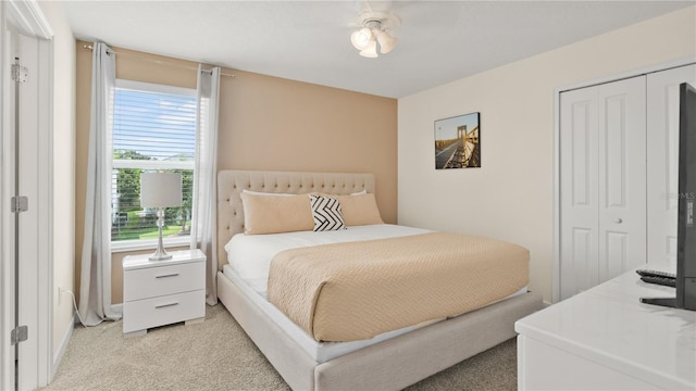 carpeted bedroom featuring ceiling fan and a closet