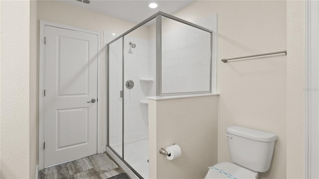 bathroom featuring hardwood / wood-style flooring, toilet, and an enclosed shower