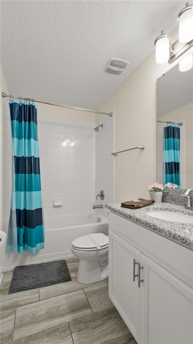 full bathroom featuring a textured ceiling, shower / tub combo with curtain, toilet, and vanity