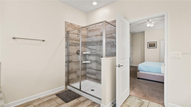 bathroom with ceiling fan and a shower with door