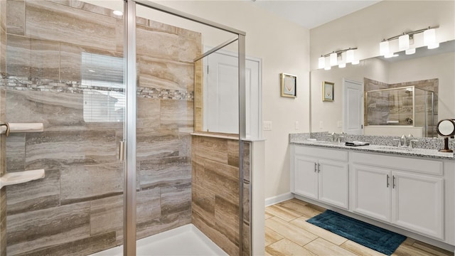 bathroom featuring double sink vanity and a shower with door