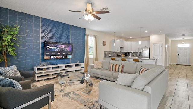 living room with sink, ceiling fan, and light tile patterned flooring